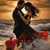 a man and a woman are dancing on the beach . the woman is wearing a long red dress .