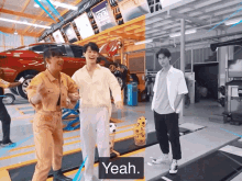 a group of people are standing in a garage and one of them says " yeah "
