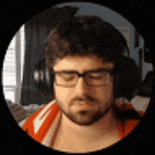 a man wearing headphones and glasses is looking down