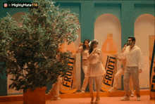 a group of people are dancing in front of a froot juice advertisement