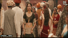 a woman in a crop top stands in a crowd of people with the words pranay varma below her