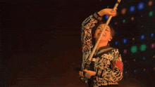 a woman wearing a shirt with chinese writing on it is holding a baseball bat
