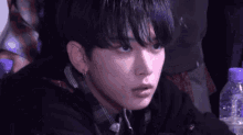 a close up of a person with a bottle of water in front of them