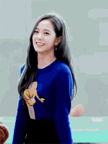 a young woman wearing a blue sweater with a monkey on it