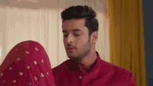a man in a red shirt is standing next to a woman in a red veil