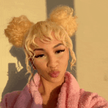 the woman is wearing a pink robe and making a funny face .