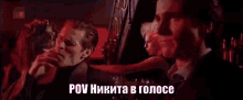a man in a suit and tie is talking to another man in a dark room in russian .