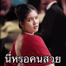 a woman in a red dress is standing in front of a sign that says ' a '