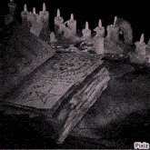 a black and white photo of a book with candles around it