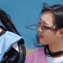 a woman with her hair blowing in the wind looks at the camera