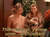 two girls looking at a book with uc on the cover