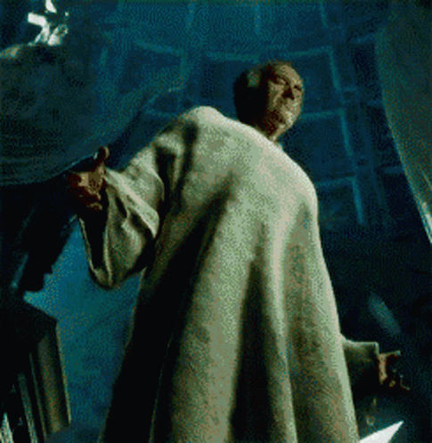 a man in a robe is standing in a dark room