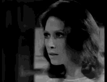 a black and white photo of a woman in a white shirt .