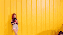 a woman with red hair is standing next to a set of stairs
