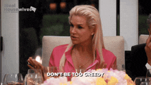 a woman sitting at a table with a sign that says real housewives on it