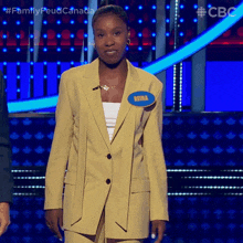 a woman wearing a yellow suit and a name tag that says reina