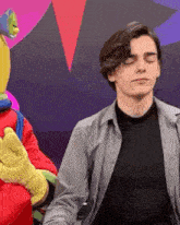 a young man is sitting in front of a stuffed animal and making a funny face .