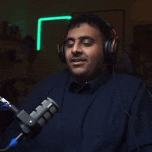 a man wearing headphones is sitting in front of a microphone