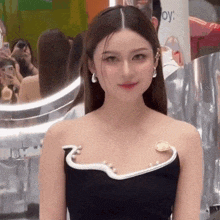 a woman in a black and white dress is standing in front of a mirror and looking at the camera .
