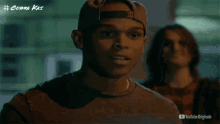 a man wearing a baseball cap is standing next to another man in a youtube originals advertisement