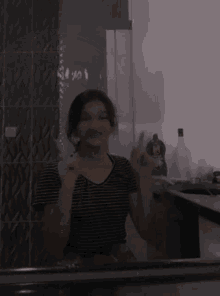 a girl is standing in front of a mirror giving the middle finger