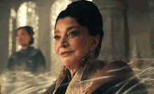 a woman is sitting in front of a window with a spider web coming out of it .