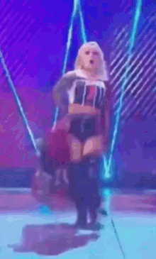 a woman is dancing on a stage with her arms outstretched in front of a crowd .