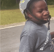 a boy wearing a helmet and a shirt that says scientific discovery