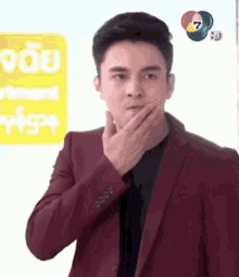 a man in a red suit is covering his mouth