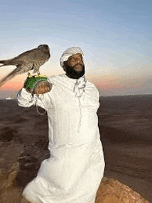 a man is holding a falcon on his shoulder .