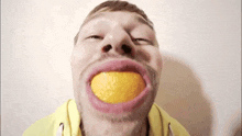 a man with an orange in his mouth making a face