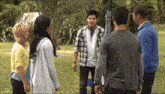 a group of people are standing in a circle talking to each other