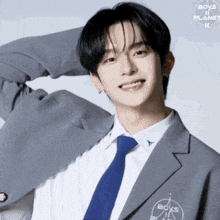 a young man wearing a suit and tie with the word boys ii planet on his chest