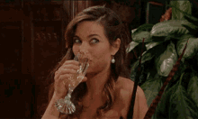 a woman is drinking from a glass of champagne .