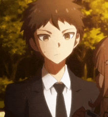 a man in a suit and tie is standing next to a girl in a park .