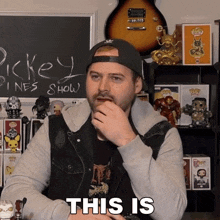 a man says this is in front of a chalkboard that says pickey