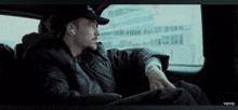 a man is sitting in the back seat of a car with the word vevo on the bottom right corner