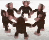 a group of stuffed monkeys are dancing in a circle holding hands .