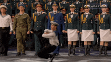 a group of people in military uniforms are dancing in front of a sign that says mediakula