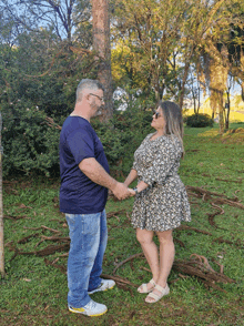 a man and woman are holding hands in a park