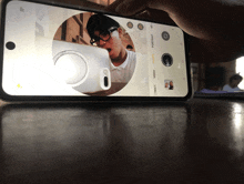 a person is taking a picture of a man in a white shirt
