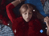 a woman laying on a bed with a red pillow