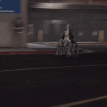 a man in a wheelchair is driving down a dark street .