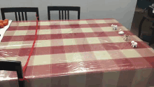 a table with a red and white checkered tablecloth and sheep on it