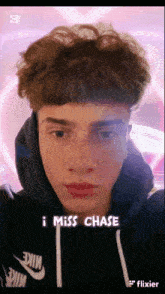 a young man is wearing a nike hoodie and has the words i miss chase on his face