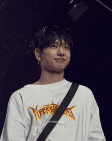 a young man wearing a white shirt that says versace on it