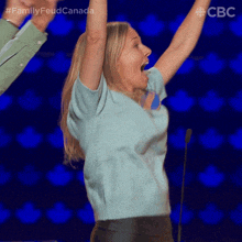 a woman is raising her arms in the air with the hashtag family feud canada