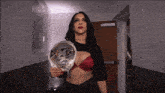 a woman is holding a nxt championship belt in her hand
