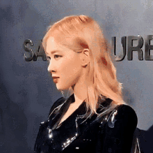 a woman with blonde hair is standing in front of a sign that says salure
