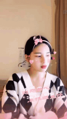 a woman wearing a headband with hearts on it looks at the camera